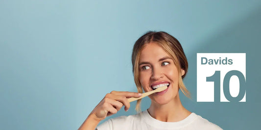 Davids 10周年のロゴと、バンブー歯ブラシで歯をみがく女性