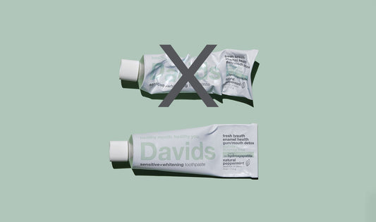 しわくちゃに握られたチューブ（×印）と、端から平らに巻かれたDavidsの金属チューブ